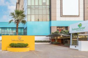 加济阿巴德考夏姆比东德里购物商场柠檬树酒店的建筑前的黄色标志