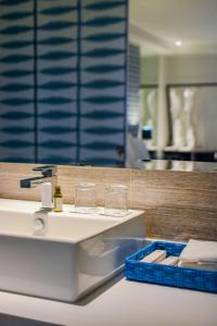 长滩岛柯伦特阿斯托里亚酒店的浴室设有水槽和玻璃杯