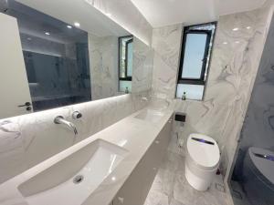 上海上海静安寺 阳光名都 豪华大三房公寓民宿 超大空间的白色的浴室设有水槽和卫生间。