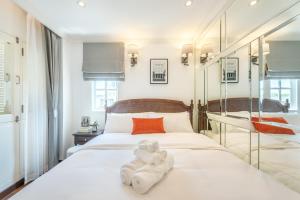 曼谷Cherie Bangkok Boutique Hotel的卧室配有白色床和毛巾