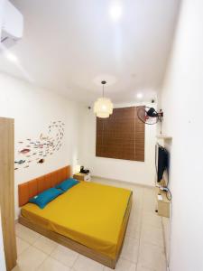 河内Michi house căn hộ đối diện bảo tàng HCM的一间卧室配有黄色的床和电视