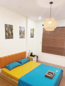 河内Michi house căn hộ đối diện bảo tàng HCM的一间卧室配有一张蓝色和黄色毯子的床