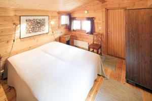 普马拉Okkolan Lomamökit的木制客房内的一间白色床卧室