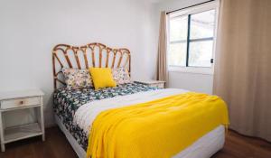 KenilworthLavender Lane Country Cottages的一间卧室配有一张带黄色毯子和窗户的床