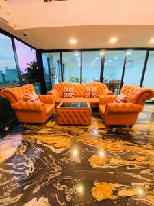 Ban Khok KhamArunsakhon luxury condo的客厅配有橙色家具和玻璃窗。