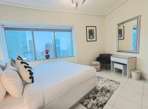 迪拜Trinity Holiday Homes - Sheikh Zayed Road Near to Financial Center Metro Station的一间卧室配有一张床、一张书桌和一个窗户。