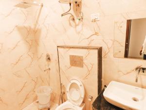 新德里Hotel Tela Suite Plaza Near IGI Airport的浴室配有白色卫生间和盥洗盆。