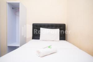 三宝垄Griya Loka 2 Syariah Near Simpang Lima Mitra Reddoorz的一间卧室配有一张白色的床和黑色床头板