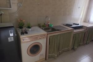 普禾加多OYO 93892 Homestay Koe Syariah的厨房配有水槽和洗衣机