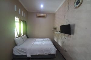 普禾加多OYO 93892 Homestay Koe Syariah的一间小卧室,配有一张床和电视