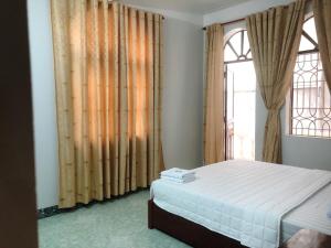 海防Hotel Nam Sơn Tân Dương的一间卧室设有一张床和一个大窗户