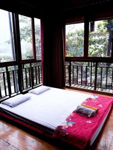 枚州县Nhà nghỉ 28 - Homestay Biên Thùy, Bản Lác, Mai Châu, Hòa Bình的配有窗户的客房内的一张大床