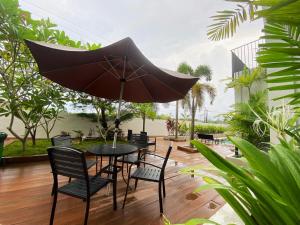 TanjungubanONYX HOTEL & VILLA的一张黑色桌子和椅子,配有雨伞