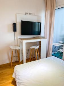 慕尼黑MyRoom Apartment in Munich的一间卧室配有一张床和一张书桌及电视