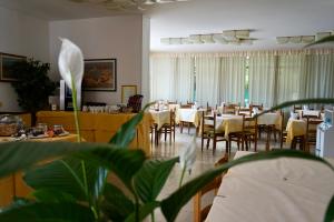 加尔达湖滨戴安娜酒店的一间在房间内配有桌椅的餐厅