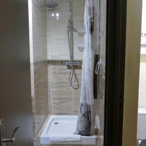 艾吉纳勒波斯奎特酒店的浴室配有浴缸和淋浴及浴帘