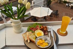 琅勃拉邦Monsane villa的桌上的一盘早餐食品,加上一杯橙汁