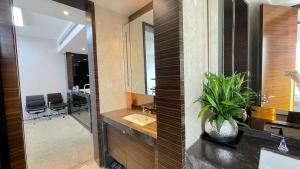 广州星驿国际公寓（广州保利世贸会展中心店）的一间带水槽和镜子的浴室以及一张书桌