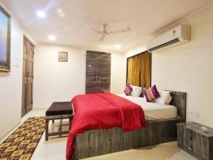 孟买Shore Beats Villa的一间卧室配有一张带红色毯子的床