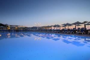 库基尼坎尼奥Arina Beach Resort的一个带椅子和遮阳伞的大型游泳池