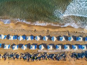 库基尼坎尼奥Arina Beach Resort的享有海滩上方的蓝色和白色遮阳伞美景