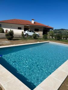 辛方伊什Quinta da Travessa的房子前面的蓝色游泳池