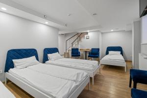 维尔纽斯Stay Express的配有两张床铺的客房配有蓝色椅子和桌子