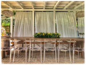 奇维塔诺瓦阿尔塔Villa Silvio的一张长桌子,上面摆放着椅子和鲜花