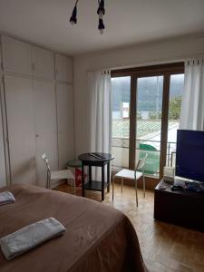 布里萨戈House1919 Via Valmara 14的一间卧室配有一张床、一张桌子和一台电视