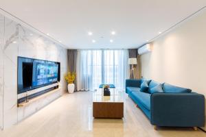 广州Serveyou Apartment - Airport Transfer Service的客厅配有蓝色的沙发和电视
