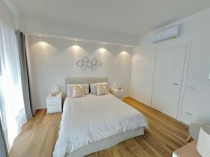 普拉托Maison BP - A 2 minuti dalla Stazione Ferroviaria的白色卧室配有一张带两个枕头的大床