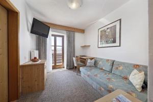 蒂鲁罗特里舍霍夫贾尼酒店的客厅配有蓝色的沙发和书桌
