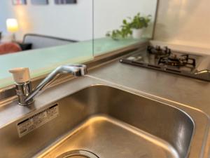 广岛OUCHI HOTEL Hatchobori的厨房里的一个不锈钢厨房水槽