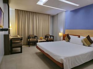 古瓦哈提Hotel Daaysco Oley Allo的卧室配有一张白色大床和一把椅子