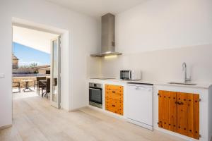 马纳科尔Son Crespi Vell 2的厨房设有白色的墙壁和木制橱柜。