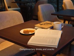 大阪大阪普米尔三井花园饭店的桌子,桌子,桌子上放着书,咖啡,盘子