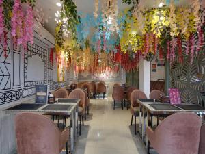 赖布尔OYO Tathastu Inn的用餐室设有桌子和天花板花卉
