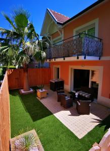 阿卡雄Appartement 90 m2 avec parking terrasse balcons, proche du port et plages的后院设有带甲板和草坪的庭院。