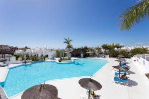 帕莱索海滩Paradise Homes Tenerife的享有带遮阳伞的游泳池和大海的景致。