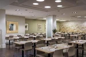 毕尔巴鄂阿万多酒店的大型用餐室配有桌椅