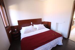 AÃ¯n el KsobVilla Tizra - guest house的一间卧室配有一张带红色和白色床单的大床