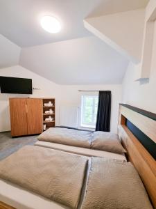 Enscherange瑞克斯密蓝酒店的一间卧室配有两张床和一台平面电视
