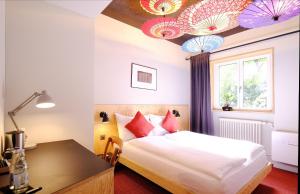 卢塞恩巴拉巴斯卢塞恩酒店的一间卧室设有一张床,天花板上配有一张桌子和遮阳伞