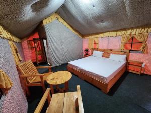 比尔瓦Hipostel Bir - Stay and Cafe的卧室配有一张床和一张桌子及椅子