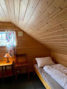 翁达尔斯内斯Trollstigen Camping and Gjestegård的卧室配有1张床、1张桌子和1把椅子
