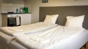 松兹瓦尔Liz Motell的一张配有白色床单和枕头的大床