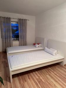 Ferienwohnung Hinzweiler的卧室在窗户前配有2张白色床