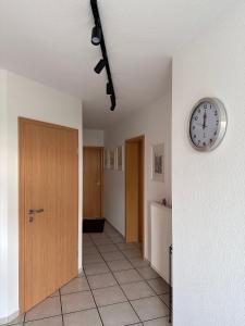 Ferienwohnung Hinzweiler的墙上的走廊和门上有一个钟