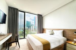 雅加达拉松纳标志酒店的一间卧室设有一张大床和一个大窗户