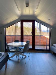 翁达尔斯内斯Trollstigen Camping and Gjestegård的客房设有桌椅和大窗户。